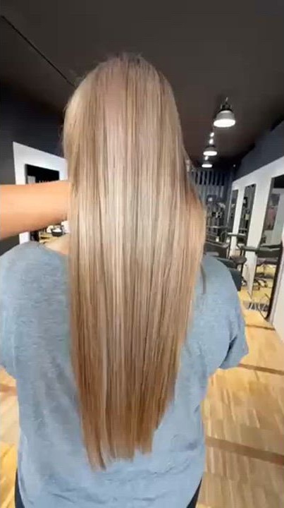 Langes, glänzend blond gesträhntes Haar nach der Behandlung im Salon
